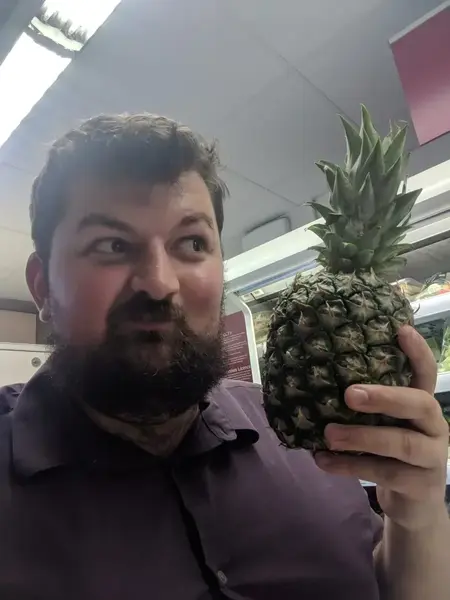 Alec holding pineapple supermarket